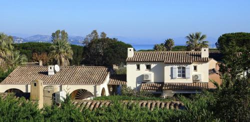 une grande maison blanche avec un toit dans l'établissement Island of calm with sea view, à Saint-Tropez