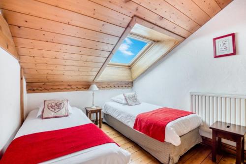 2 camas num quarto no sótão com tectos em madeira em Résidence La Ginabelle - maeva Home - Appartement 4 Pièces 8 Personnes - Séle 65 em Chamonix-Mont-Blanc