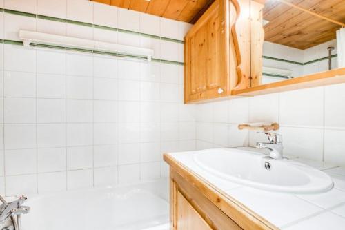 uma casa de banho com um lavatório e uma banheira em Résidence La Ginabelle - maeva Home - Appartement 4 Pièces 8 Personnes - Séle 65 em Chamonix-Mont-Blanc