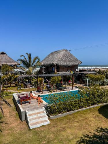 a resort with a swimming pool and a beach at Kite Eco House Salinas del rey in Salina de Rey