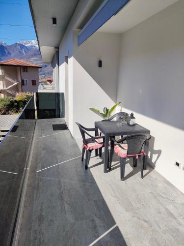 a patio with a table and chairs on a balcony at Appartamento Meridiana in Arco