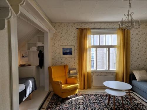 a bedroom with a bed and a chair and a table at Charming wooden house apartment 48 m2 in Turku