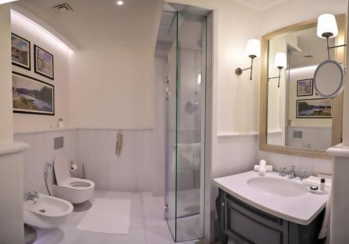 e bagno con servizi igienici, lavandino e doccia. di 21 High Street Residence a Doha