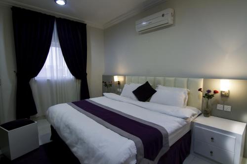 Habitación de hotel con cama grande y ventana en Rofan Hotel Suites en Riad