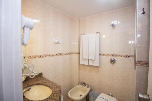 a bathroom with a toilet and a sink at Trevi Hotel e Business in Curitiba