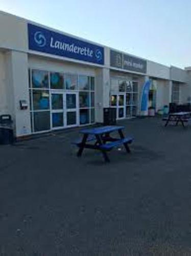 a building with a picnic table in front of it at Premium location - Sleeps 6 - Caravan on The Lakes in Mablethorpe
