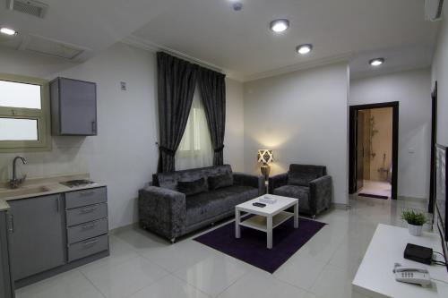 een woonkamer met twee banken en een tafel bij Rofan house serviced apartments in Riyad