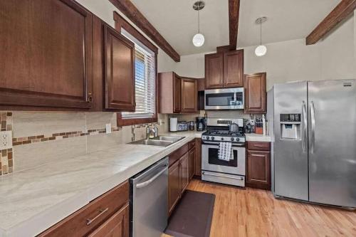 a kitchen with wooden cabinets and stainless steel appliances at Walk to Everything Bikes AC Dog Friendly in Bend