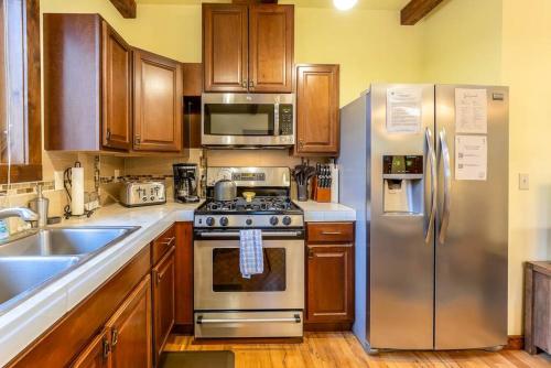 a kitchen with stainless steel appliances and wooden cabinets at Walk to Everything Bikes AC Dog Friendly in Bend