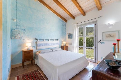 sypialnia z białym łóżkiem i oknem w obiekcie B&B Calata Di Soli w mieście Miniera dellʼArgentiera
