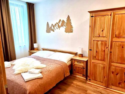 a bedroom with a bed and a cabinet and a window at Paseky Apartments Resort in Nové Město na Moravě