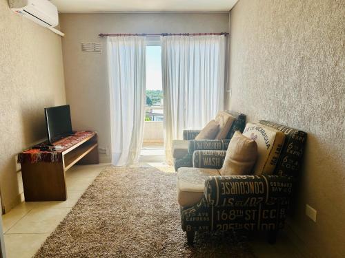 Una sala de estar con un sofá y una silla y una ventana. en depto 82, en Cañuelas