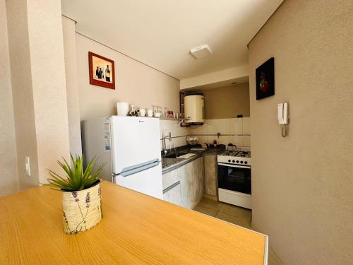 Una cocina con una mesa y un refrigerador blanco. en depto 82, en Cañuelas