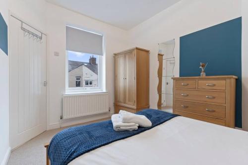 a bedroom with a bed and a dresser and a window at Elton House - Prime Location - Free Parking, Fast WiFi and Smart TV by Yoko Property in Redcar
