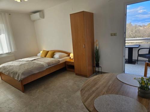 sypialnia z łóżkiem, stołem i oknem w obiekcie Studio Busilak w mieście Vrh