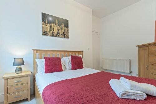 a bedroom with a large bed with a red blanket at Elton House - Prime Location - Free Parking, Fast WiFi and Smart TV by Yoko Property in Redcar