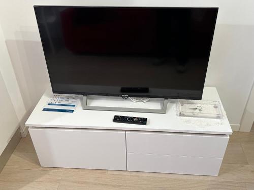 a tv on a white dresser with a television on it at RESIDENCE BIANCOVERDE in Rovereto