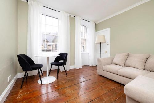 ein Wohnzimmer mit einem Sofa, einem Tisch und Stühlen in der Unterkunft Royal Mile Apartments in Edinburgh
