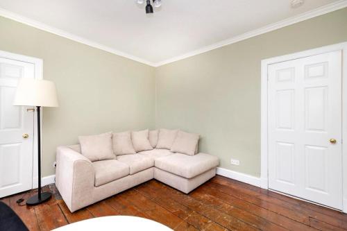 ein Wohnzimmer mit einem weißen Sofa und einer Lampe in der Unterkunft Royal Mile Apartments in Edinburgh
