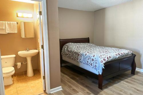 een kleine badkamer met een bed en een wastafel bij Sparta Seven Motel By OYO near Milledgeville in Sparta