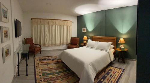 a bedroom with a white bed and a green wall at Quinta Ascensión Hotel Boutique Only Adults in Malinalco