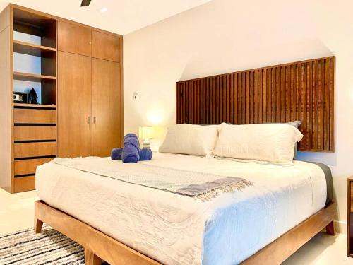 a bedroom with a large bed with a wooden headboard at Marila by Andiani Travel in Playa del Carmen