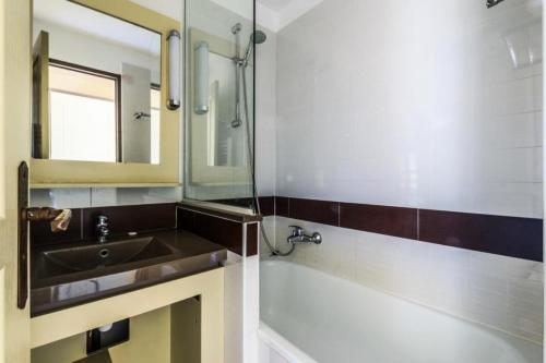 une salle de bain avec un lavabo et un miroir dans l'établissement Résidence le Village de Cap Esterel - maeva Home - Appartement 2 Pièces 5 Personnes - Sélection MAE-5927, à Saint-Raphaël