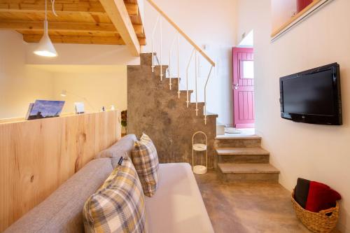 a living room with a couch and a tv and stairs at Sefardita - Guest House in Castelo de Vide