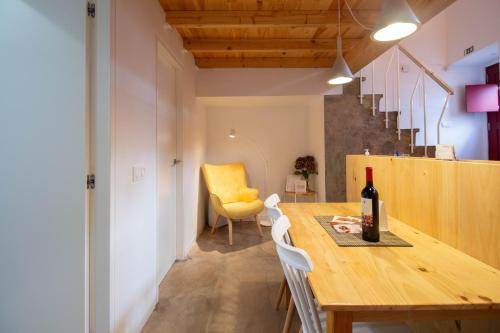 a dining room with a table and a yellow chair at Sefardita - Guest House in Castelo de Vide