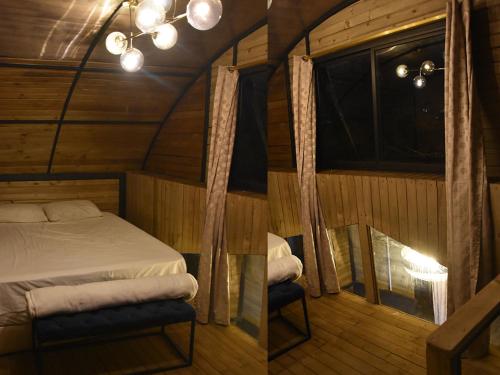 Dormitorio con cama y ventana en una cabaña en Omghat Glamping - Cabaña Shiva, en El Peñol