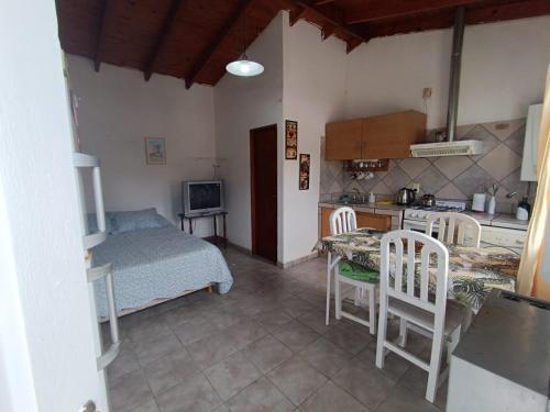 Cette chambre comprend une cuisine, une table et un lit. dans l'établissement Canelo departamento, à Ushuaia