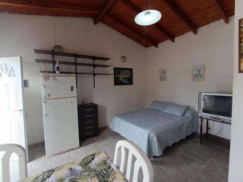 a kitchen with a bed and a refrigerator and a tv at Canelo departamento in Ushuaia
