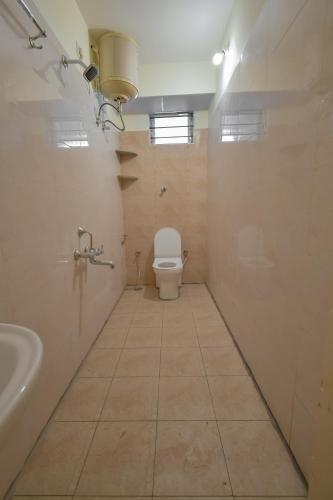 a bathroom with a toilet and a sink at HomeSlice Whitefield in Bengaluru