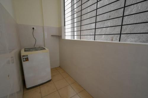 a small refrigerator in a room with a window at HomeSlice Whitefield in Bengaluru