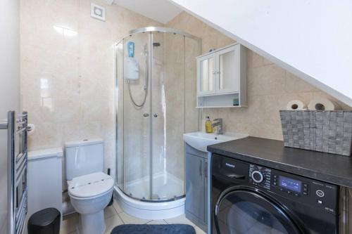 a bathroom with a shower and a toilet and a sink at Rugby Coach House, Central location, 5 star rating in Rugby
