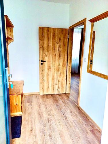 an empty room with a wooden door and wooden floors at Paseky Apartments Resort in Nové Město na Moravě