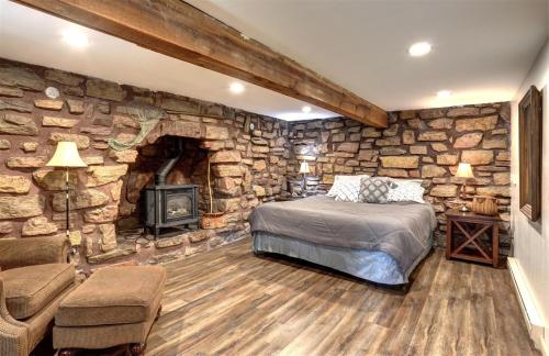 a stone walled bedroom with a bed and a fireplace at Trail Mountain Cabin in Lead