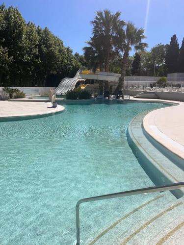 - une piscine avec toboggan dans un parc dans l'établissement Bungalow charmant à Agde avec piscine partagée, à Agde