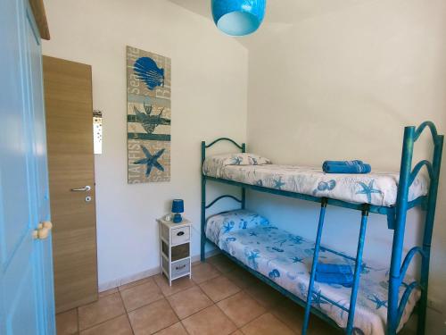 キアにあるChia casa mare vacanze Sterliziaのベッドルーム1室(二段ベッド2台、ドア付)