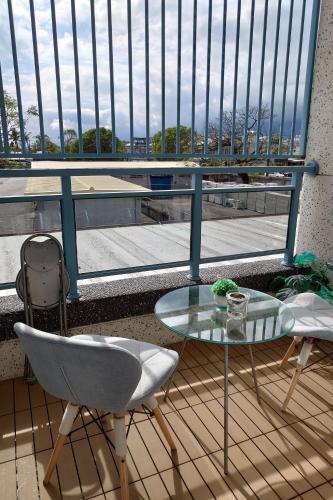 a balcony with a glass table and chairs and a view at 台東市民宿賞星月沐文創館Enjoy Star丨網紅民宿丨親子友善丨寵物友善丨療癒民宿丨可包棟自動麻將機卡拉OK機丨雅致庭院丨近機場娜路彎酒店 l 可自助入住 in Taitung City