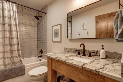 a bathroom with a sink and a toilet and a mirror at The Cottonwood in Lead