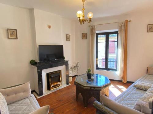 un salon avec une cheminée et une télévision dans l'établissement La Maison des Templiers ~ Ostal Médiéval ~ Logis enchantés, à Carcassonne