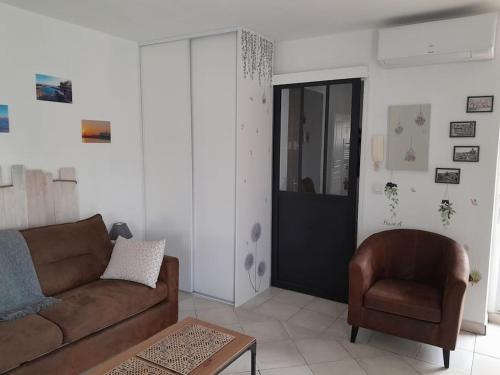 un salon avec un canapé et une chaise dans l'établissement Charmant studio lumineux avec parking privé, à Saint-Raphaël
