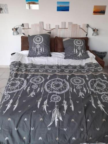 - un lit avec une couette et des oreillers en noir et blanc dans l'établissement Charmant studio lumineux avec parking privé, à Saint-Raphaël
