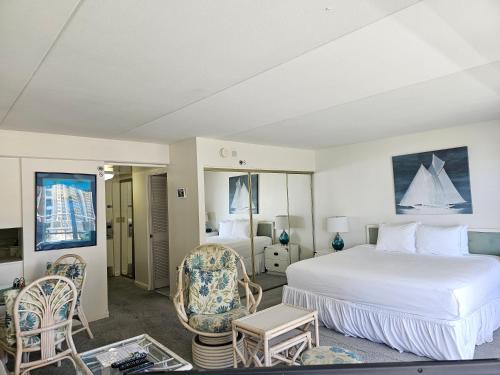 - une chambre avec un grand lit blanc et des chaises dans l'établissement Ilikai Tower 1240 Lagoon View 1BR, à Honolulu