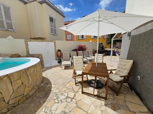 eine Terrasse mit einem Tisch, Stühlen und einem Sonnenschirm in der Unterkunft Hidden Paradise in San Bartolomé de Tirajana