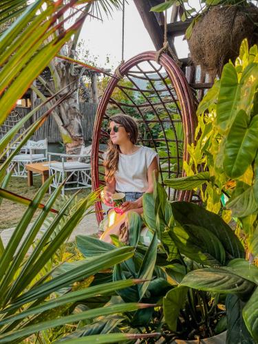 a woman sitting in a wicker chair in a garden at Kite Eco House Salinas del rey in Salina de Rey