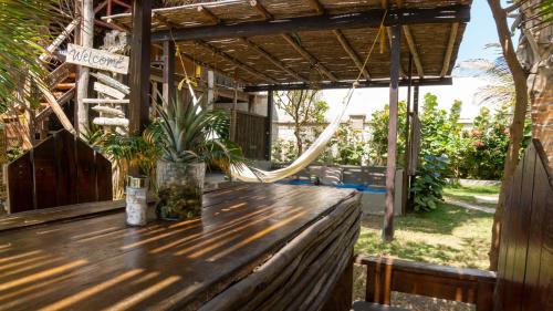 a wooden table on a porch with a hammock at Kite Eco House Salinas del rey in Salina de Rey