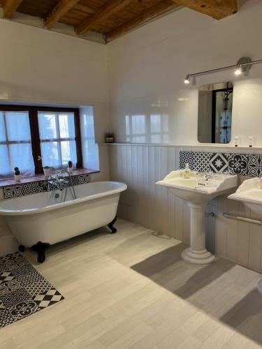 ein großes Bad mit einer Badewanne und einem Waschbecken in der Unterkunft Domaine Saladry in Villepinte