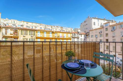 a table on a balcony with a view of buildings at Nice Renting - 9b Massena - Chic Escape in the Heart of Nice Comfort & Charm ! in Nice
